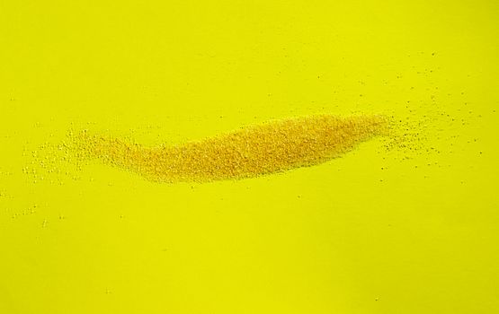 Yellow grains of cornmeal  on colored background ,it’s a common staple food  of Northen Italian called polenta