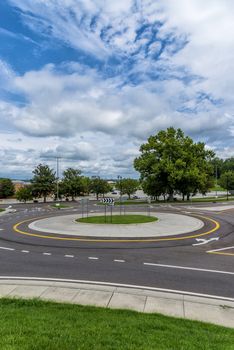 Vertical shot of a traffic roundabout with a blue cloudy sky.
