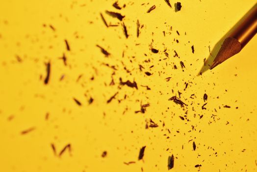  Sharpened wooden pencil on yellow background , beautiful pencil shavings all around 