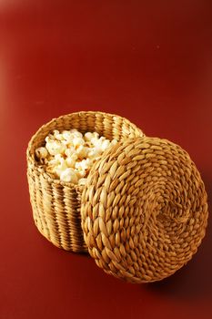 popcorn in basket isolated over red background
