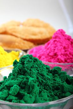 multiple holi colors with gujiya at background