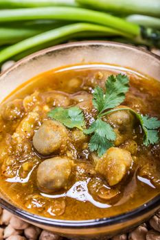 spicy chana masala, raw chickpeas around the bowl with green chilli topping, indian dish