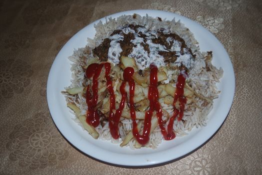 Delicious traditional dish of rice with potato fries and cereals with red ketchup. Food background with copy space for text and advertisements.