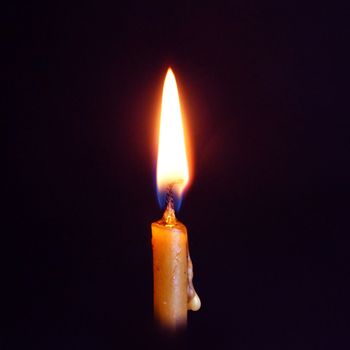 burning wax candle close up on dark background, square photo