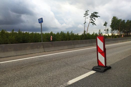 broken road sign on an empty track on a curtain day.