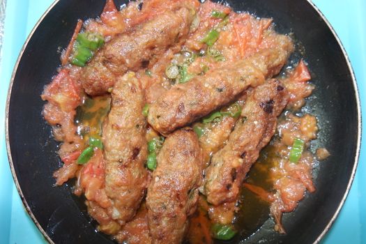 Closeup view of delicious spicy home made fried kebab with green mint leaves and green pepper sprinkled on it