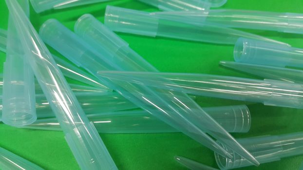 Close up view of micro litre tips on green floor sheet with empty holes. Reseach lab. tool for accurate measurement.