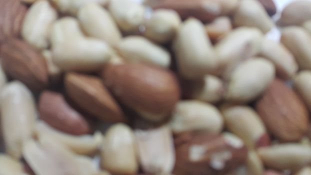 Closeup view of mixed dried and roasted  peanuts and almonds. A fruit for background text