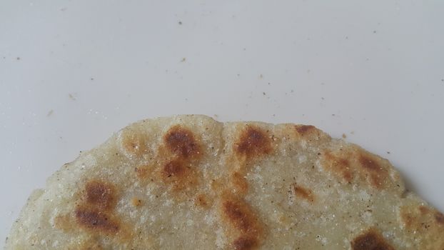 Closeup view of of traditional bread called Jawar roti or bhakri on white background. Bhakri is a round flat unleavened bread often used in the cuisine of many Asian countries
