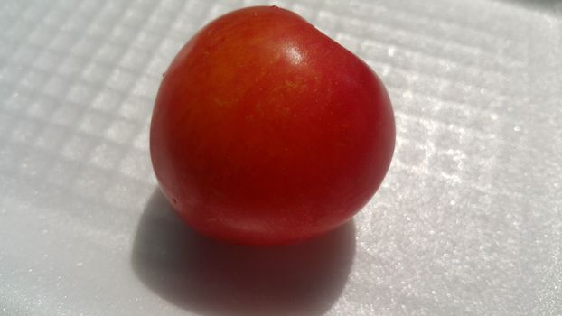 Closeup view of red plum on a white grey background. Freshly harvested plum making heart shape appearance in the view from angle.