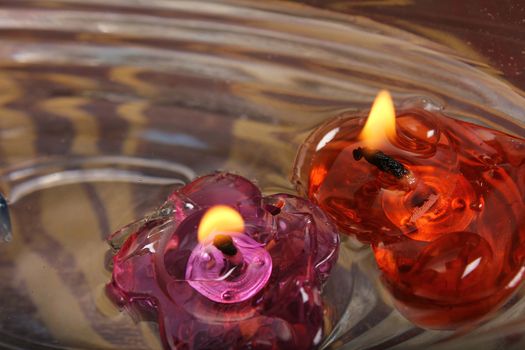 floating burning candles in glass aroma bowl