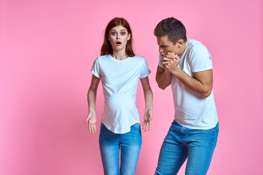 pregnant mom and happy father on pink background Young family waiting for baby. High quality photo