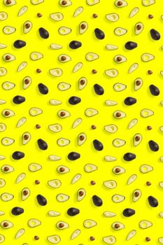 Avocado. Background made from isolated Avocado pieces on yellow background. Flat lay of fresh ripe avocados and avacado pieces