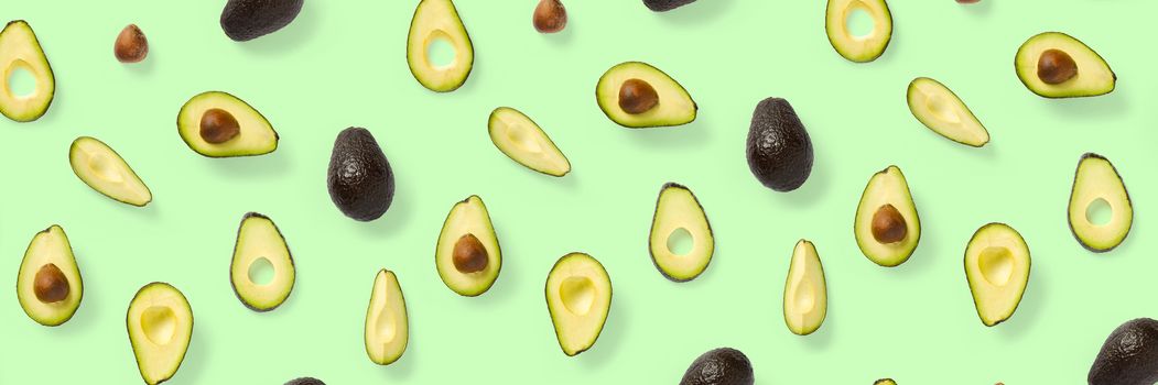 Avocado banner. Background made from isolated Avocado pieces on green background. Flat lay of fresh ripe avocados and avacado pieces