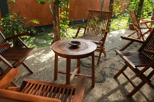 Set of wooden table and chairs in the garden. Teak wood furniture stand on the terrace.
