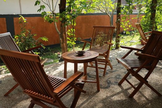 Set of wooden table and chairs in the garden. Teak wood furniture stand on the terrace.