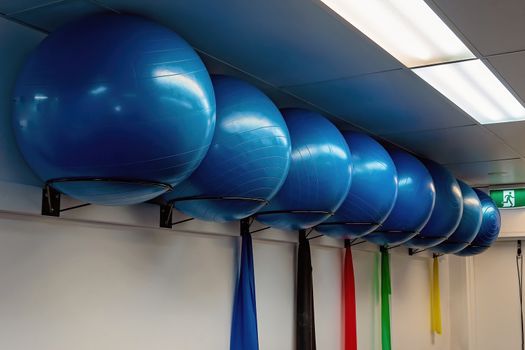 Large round blue pilates exercise balls in a row in a physiotherapist clinic