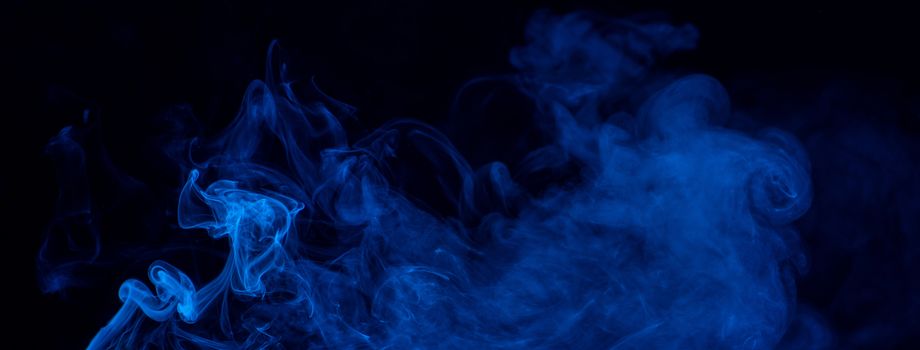 Conceptual image of blue color smoke isolated on dark black background, Halloween design element concept.