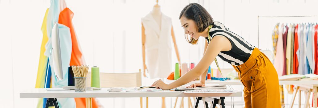 Young Asian designer woman working with computer and choosing multicolor chart at workplace, small business startup, Business owner entrepreneur, modern freelance job lifestyle concept. asia people