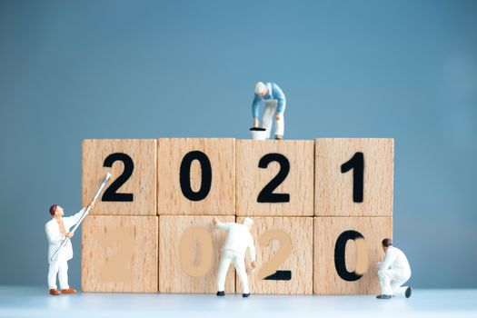 Miniature worker team painted number 2021 and remove number 2020 , Happy new year concept