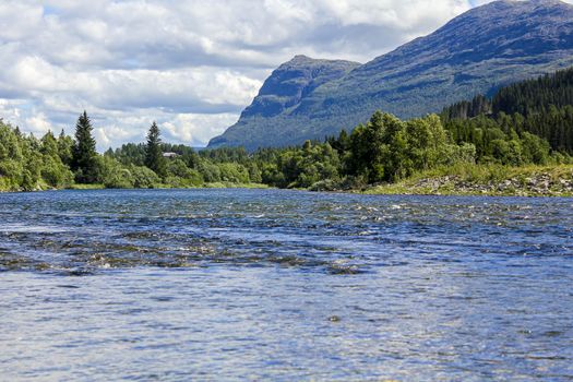 Flowing beautiful river lake Hemsila with mountain panorama in Hemsedal, Viken, Buskerud, Norway.