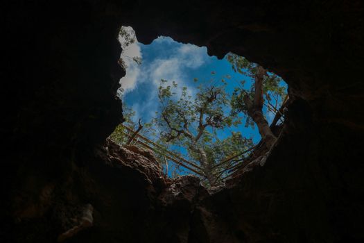 View from inside a cave looking out.Fallen cave ceiling. A hole in the ceiling of the cave.