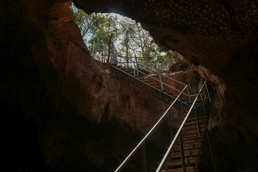 Stainless steel staircase in the cave. Stainless steel staircase to GOA BANGKANG PRABU cave, a bat cave on Lombok island, Indonesia. Bottom view of the blue sky.