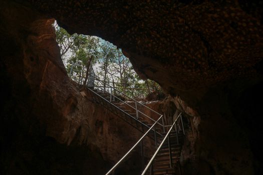 Stainless steel staircase in the cave. Stainless steel staircase to GOA BANGKANG PRABU cave, a bat cave on Lombok island, Indonesia. Bottom view of the blue sky.