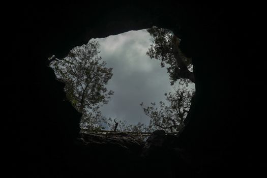 View from inside a cave looking out.Fallen cave ceiling. A hole in the ceiling of the cave.