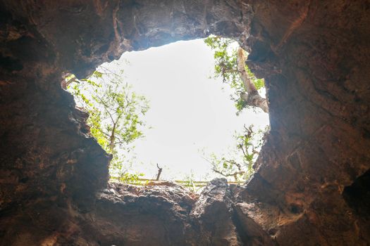 View from inside a cave looking out.Fallen cave ceiling. A hole in the ceiling of the cave.