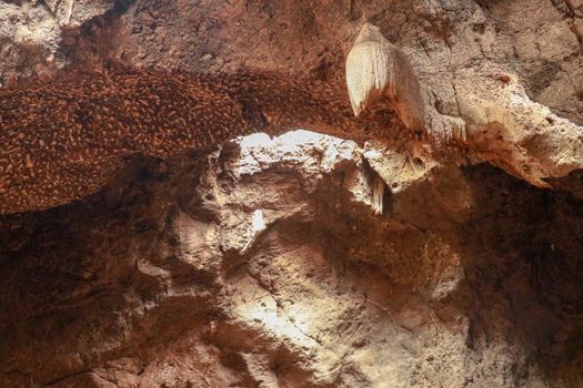 Stalactites hanging from the ceiling of the cave underground. Mountain nature. Habitat of bats. Fallen cave ceiling. A hole in the ceiling of the cave.