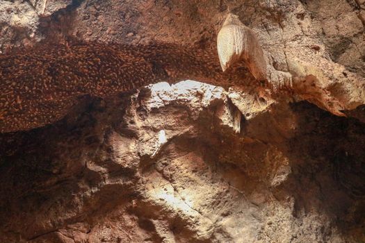 Stalactites hanging from the ceiling of the cave underground. Mountain nature. Habitat of bats. Fallen cave ceiling. A hole in the ceiling of the cave.