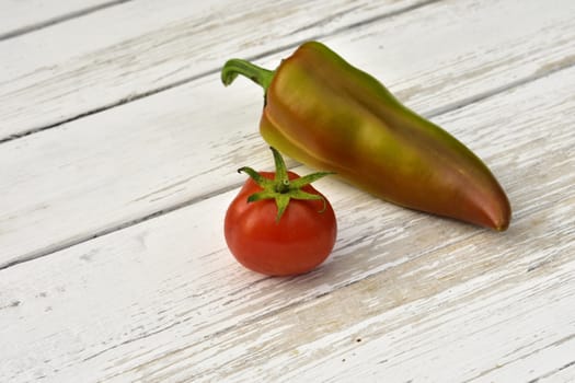 red tomato and bell pepper pod on a wooden vintage table