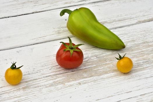 red tomato, two yellow small tomatoes and bell pepper pod
