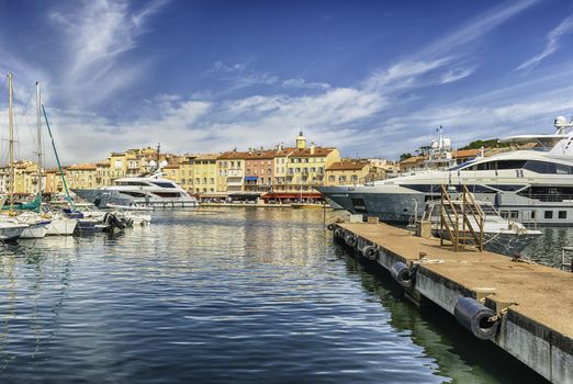 View of the old harbor with luxury yachts of Saint-Tropez, Cote d'Azur, France. The town is a worldwide famous resort for the European and American jet set and tourists