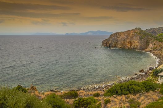 Rocky coast crag on the island of panarea and on the horizon other islands of the archipelago of the aeolian islands