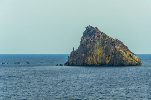 Isolated volcanic rock in the tyrrhenian sea in front of the coast of panarea island