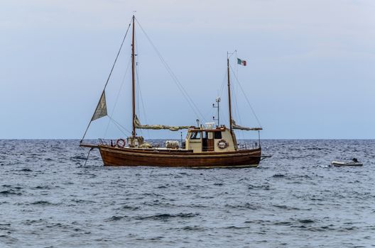 Sailboat and its lifeboat in waters of the Tyrrhenian sea off the island of lipari italy