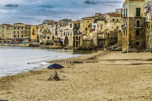 City of cefalu north of sicily sand sea and old constructions located at the foot of the beach island of sicily