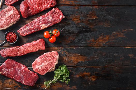 Set of flap flank Steak, machete steak or skirt cut, Top blade or flat iron beef and tri tip, triangle roast with denver cut top view over old butcher wood table space for text.
