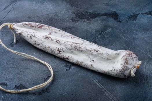 Whole spanish longaniza wurst on blue background.