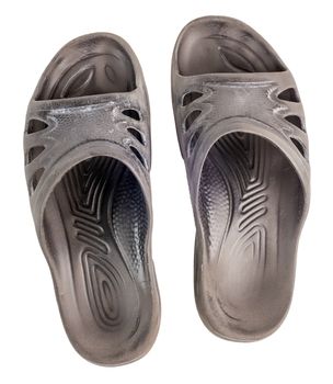 A pair of old black rubber slippers isolated on white background, view from above.