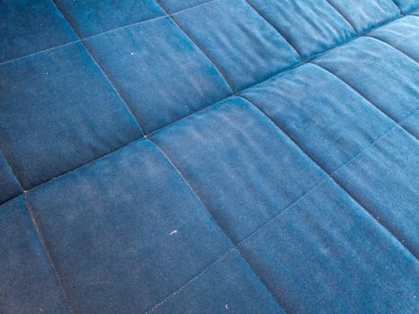 flat surface of dusty blue bed or sofa - closeup with selective focus.