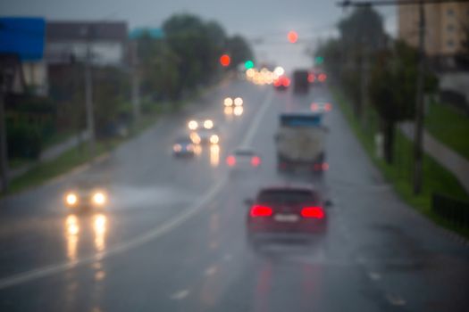 Defocused picture of evening city street car traffic after rain - view from road.
