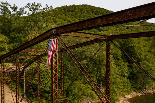 Aerial view of torn damaged Stars and Stripes flag on the historic metal truss Jenkinsburg Bridge near Morgantown