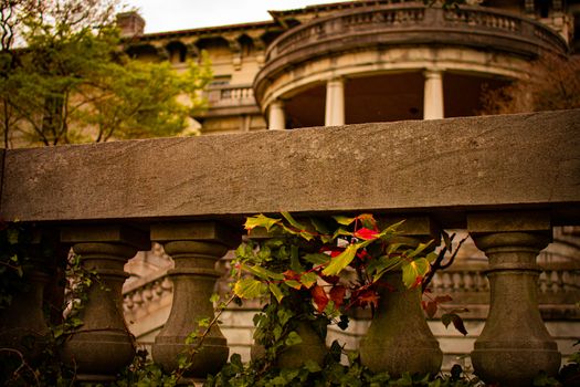 An Ornamental Stone Fence in Front of a Mansion Covered in Ivy
