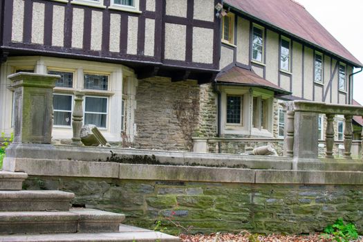 A Broken Piece of the Detailed Stone FEnce Surrounding an Old Fashioned Cobblestone Building