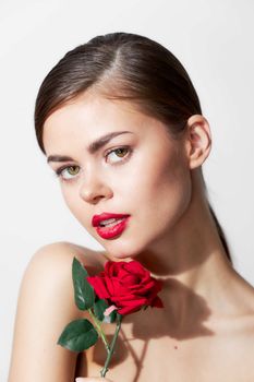 Woman with rose Red lips bared shoulders spa treatments bright makeup light background