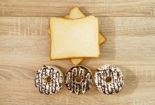 Top view Round donuts slice of bread on wood background