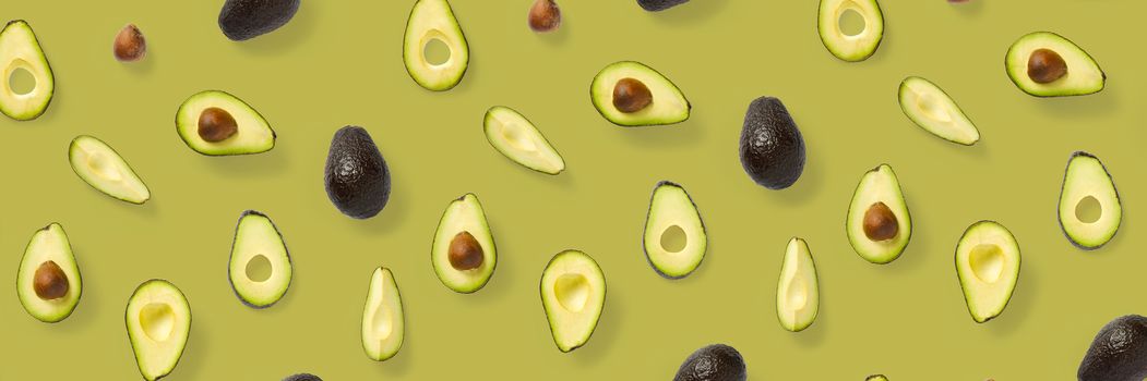 Avocado banner. Background made from isolated Avocado pieces on olive color background. Flat lay of fresh ripe avocados and avacado pieces